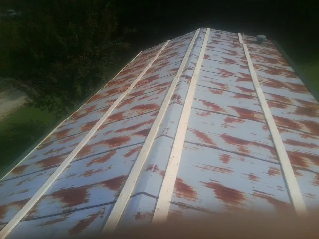 Rusted metal roof panels with new wood purlins before replacement — Storm Damage Roof Repair in Schellsburg by Roofing Brothers