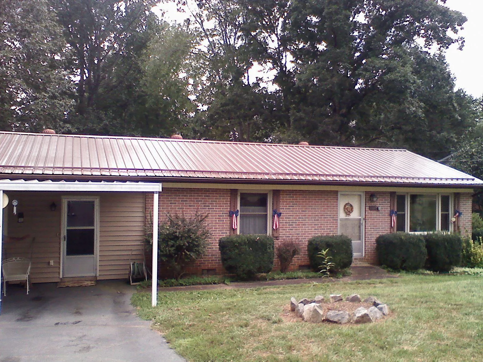 Bronze metal roof and carport on a brick ranch home — Roof Repair work by our crew in Schellsburg